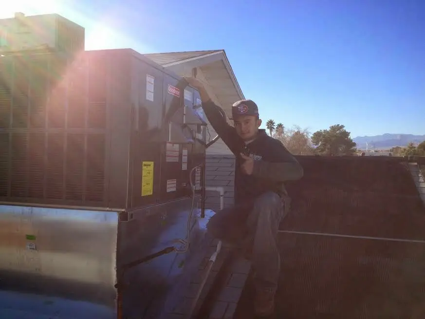 HVAC technician performing Heat Pump Repair on a rooftop unit in Winchester